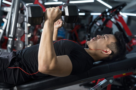 Close-up of fitness man, Handsome athletic guy workout with dumbbellsの写真素材
