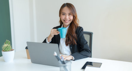 Shot of happy young asian woman looking at camera, Attractive businesswoman working on laptop in her workstation office.の写真素材