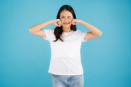 Asian girl holding a cup of pearl milk tea With a smile, fun and happiness on a blue background.の写真素材