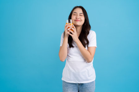 A beautiful woman in a red shirt sitting on the sofa happy smile and feel relaxed.の写真素材