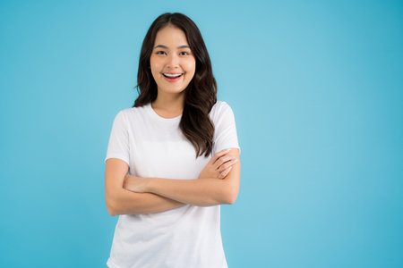 A beautiful woman in a red shirt sitting on the sofa happy smile and feel relaxed.の写真素材