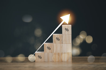 Interest rate financial and mortgage rates concept. Wooden blocks with Icon percentage symbol and arrow pointing up. The economy is improving.の写真素材