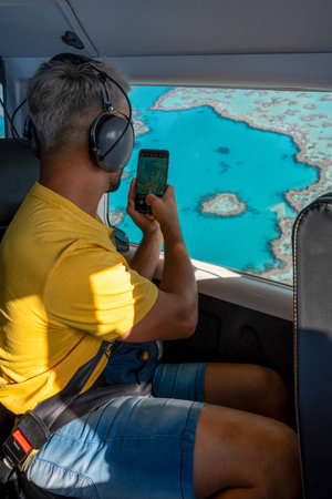 Traveler capturing heart reef aerial view from scenic flight