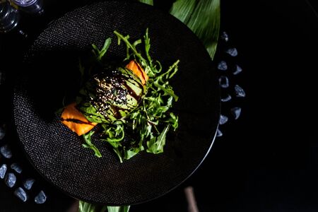 burger, juicy vegan burger, avocado burger, on a black background, fast food, hamburger. Vegan big burger with salmon served on black plate.の写真素材