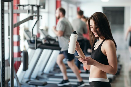 Beautiful sexy woman with a sports body in black and white sportswear trains in the gym. Sport activitiesの写真素材