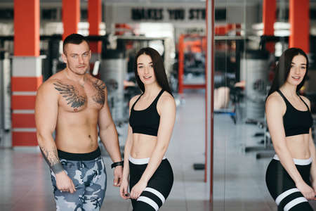 A man and a woman of a sports body build together in the gym. Healthy Lifestyleの写真素材