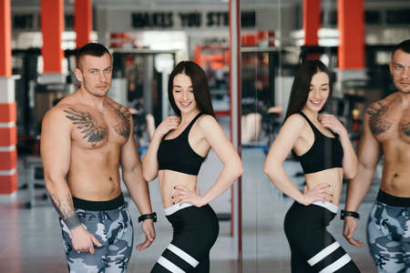 A man and a woman of a sports body build together in the gym. Healthy Lifestyleの写真素材