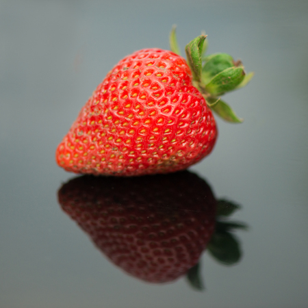 Fresh strawberries on black with reflectionの写真素材