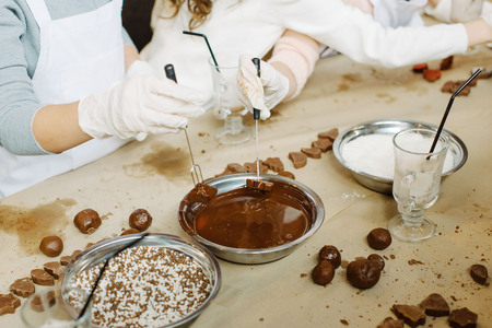 Young girls making chocolate candy. Sweets for celebrationの写真素材