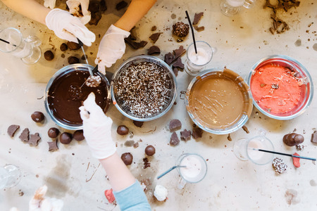 Young girls making chocolate candy. Sweets for celebrationの写真素材