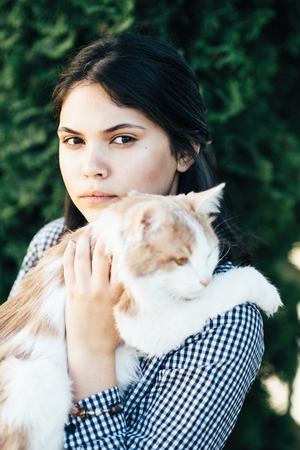 Cute girl holds spotted cat in her armsの写真素材