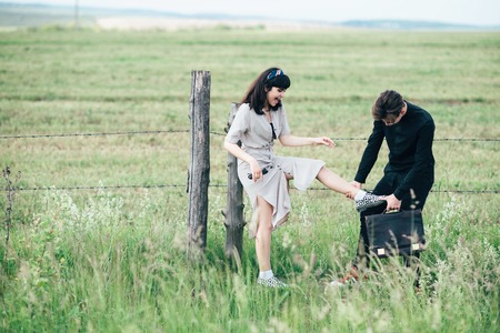 Cute young guy standing next to a beautiful girl on a green background behind a city.の写真素材