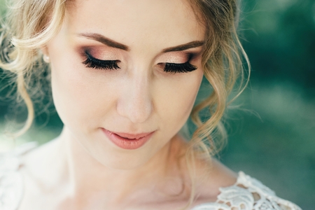 Beautiful bride with a wedding bouquet in their hands outdoors in a park. Wedding dayの写真素材