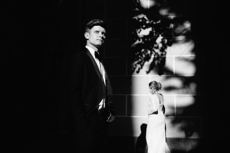 A young, sympathetic couple strolling around the city and posing against the background of the pink wallの写真素材