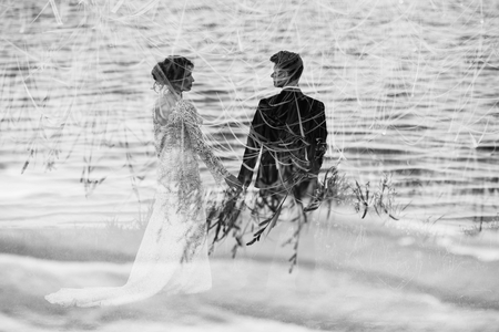 The young cute couple walks and spends time at the local beach near the lakeの写真素材