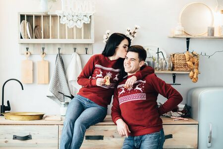 Man and woman hugging in a kitchen on the eve of the New Year holidays.の写真素材