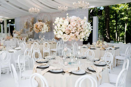 Festive wedding table setting with flowers, napkins, cutlery, glasses, bright summer table decor. Wedding decorの写真素材