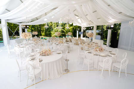 Festive wedding table setting with flowers, napkins, cutlery, glasses, bright summer table decor. Wedding decorの写真素材