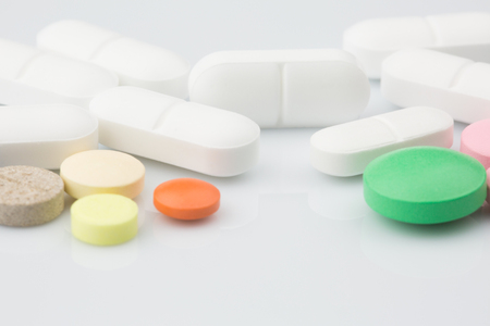 Pharmacy theme. Multicolored Isolated Pills and Capsules on the White Surface. Closeupの写真素材