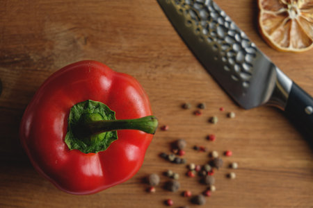 Red pepper and knife on wooden table, top view. food backgroundの写真素材