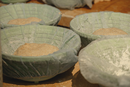 Crafting traditional dough in artisan bowls at a rustic kitchen during the early morning light,...