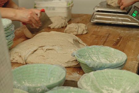 Bakers skillfully shaping dough and preparing for a delicious bread-making process in a cozy kitchen...