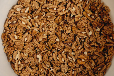 Freshly shelled walnuts piled high in a rustic bowl gleaned from a weekend harvest in the...