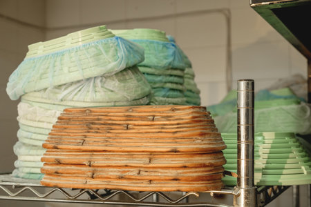 Stacks of colorful trays in a bustling kitchen during the afternoon preparation for a local culinary...