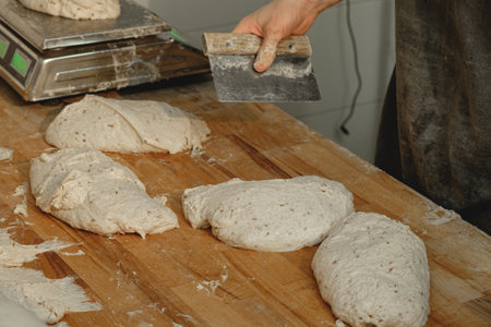 Crafting artisanal bread at a bustling bakery in the heart of the city during early morning hoursの写真素材
