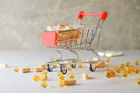 Mini shopping cart filled with diet supplements on a clean surfaceの写真素材