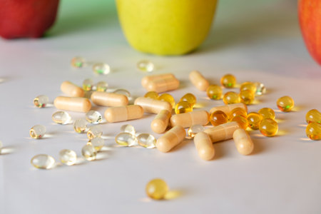 Brightly colored supplements alongside fresh fruit on a clean surfaceの写真素材