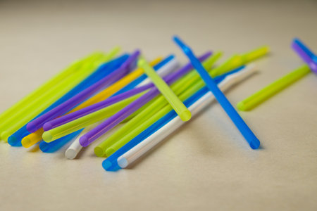 Colorful plastic sticks create playful arrangements on a smooth surfaceの写真素材