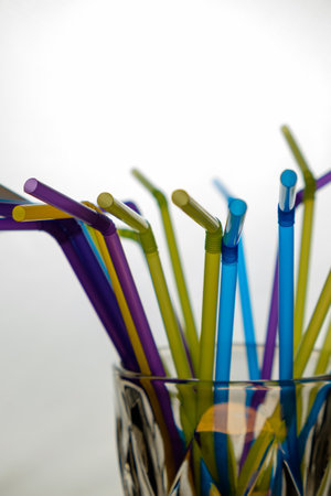 Colorful reusable straws create a vibrant display in a glass containerの写真素材
