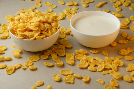 Crunchy corn flakes and creamy milk create a delightful breakfast spreadの写真素材