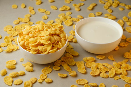 Morning delight with crunchy corn flakes and creamy milk in bright kitchenの写真素材