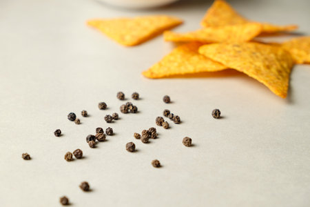 Crisp nacho chips paired with flavorful spices on a clean surfaceの写真素材