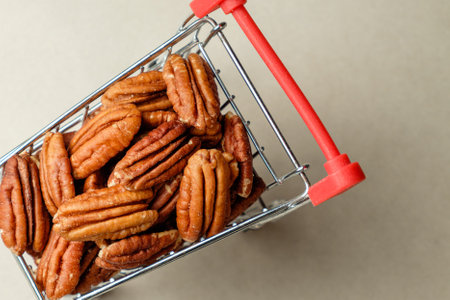 Harvested pecan nuts nestled in a vibrant miniature shopping cartの写真素材