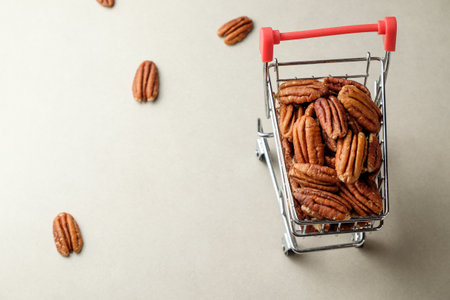 Exploring the delightful world of pecan nuts in a miniature shopping cartの写真素材