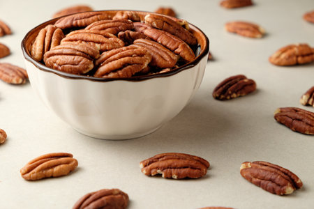 Delicious pecan nuts arranged beautifully around a bowl on a tableの写真素材