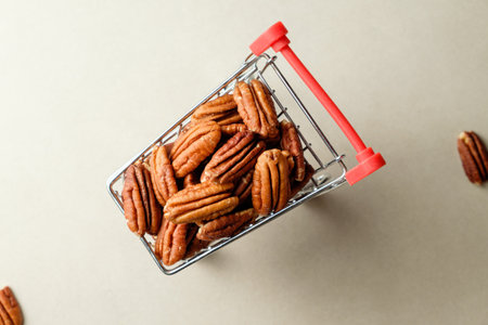 Pecan nuts fill a miniature shopping cart, ready for culinary adventuresの写真素材