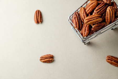 Delightful pecan nuts spilling from a cute basket on a soft surfaceの写真素材