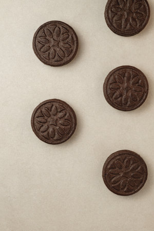 Delicious chocolate sandwich cookies arranged beautifully on a light surfaceの写真素材