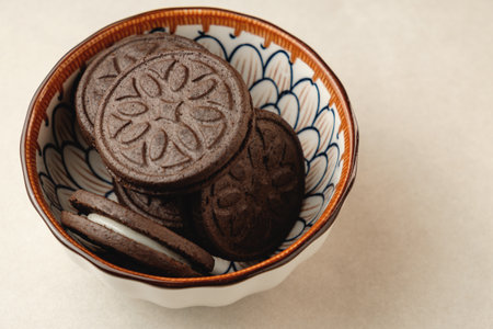 Delicious chocolate cookies in a decorative bowl on a light surfaceの写真素材