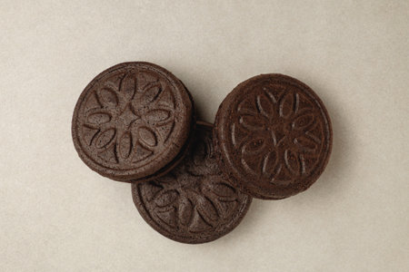 Delicious chocolate cookies arranged in an artistic display on a beige surfaceの写真素材