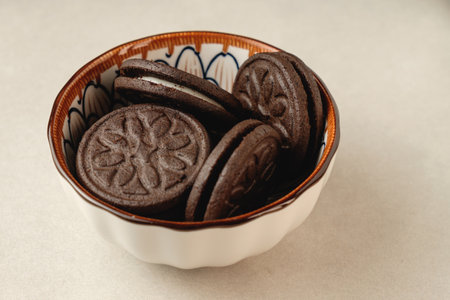 Delightful chocolate cookies arranged in a colorful bowl at homeの写真素材