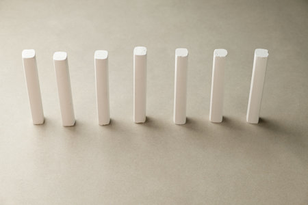 White chalk pieces arranged in a perfect row on a smooth surfaceの写真素材