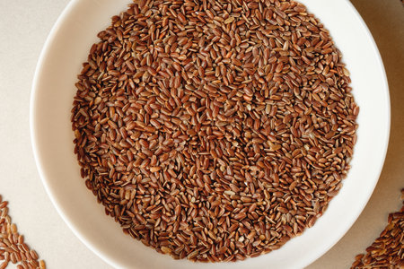 Organic brown rice in a wide bowl highlighting its natural beauty and textureの写真素材