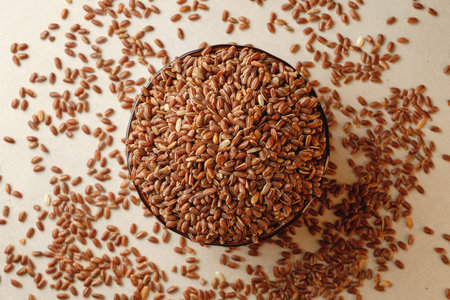 Delicious brown rice nestled in a rustic bowl on a plain surfaceの写真素材
