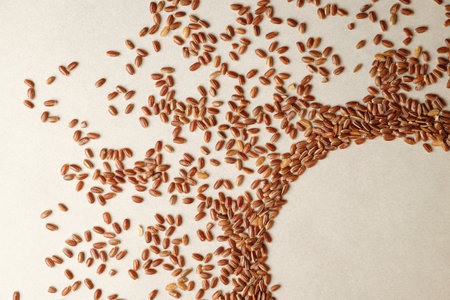 Discover the beauty of brown rice scattered artfully on a surfaceの写真素材