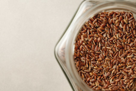 Organic brown rice resting in a clear glass jar showing its rich textureの写真素材